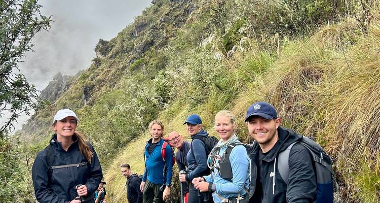 Smiling trekkers pause on a misty, steep section of the Inca Trail.