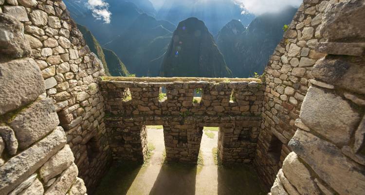 Vue à travers les structures en pierre du Machu Picchu avec les montagnes en arrière-plan.