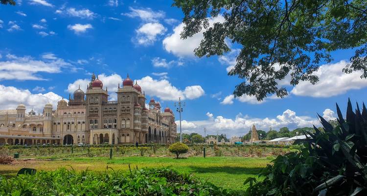Un palais historique avec un jardin au premier plan sous un ciel bleu.
