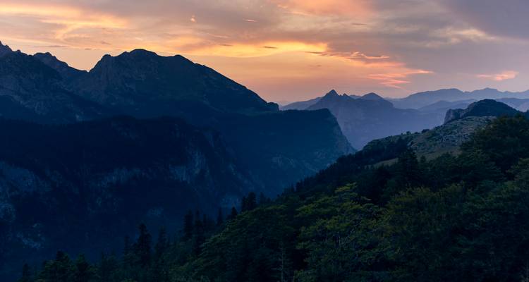 Sanfte Dämmerungsfarben malen nach Sonnenuntergang entfernte Bergrücken und Täler an.