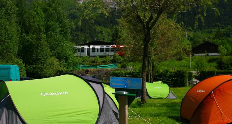 Camping avec tentes et passage d'un train.