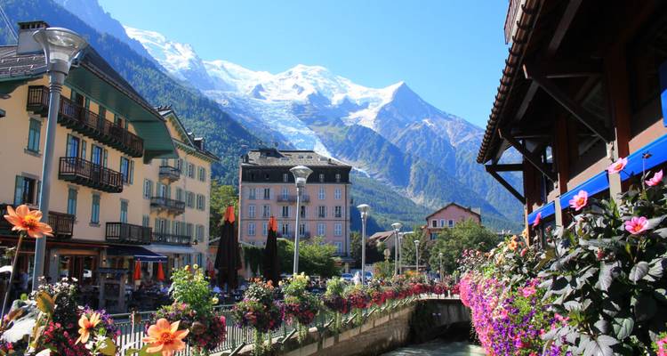 Schilderachtig straatje in Chamonix omzoomd met bloemen tegen de achtergrond van alpiene pieken en gletsjers.