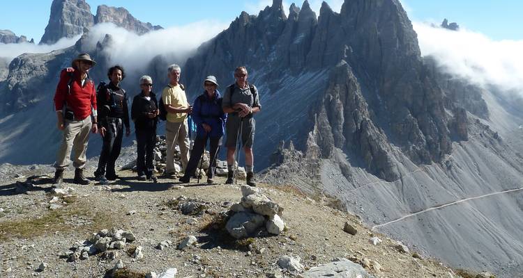 Foto de grupo de excursionistas con los picos de las montañas al fondo.