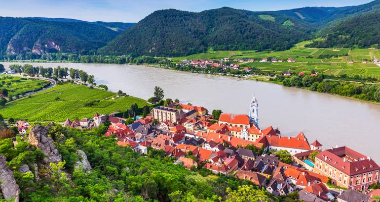 Charmantes Wachauer Dorf Dürnstein mit blauem Kirchturm an der Donau und Weinbergen.