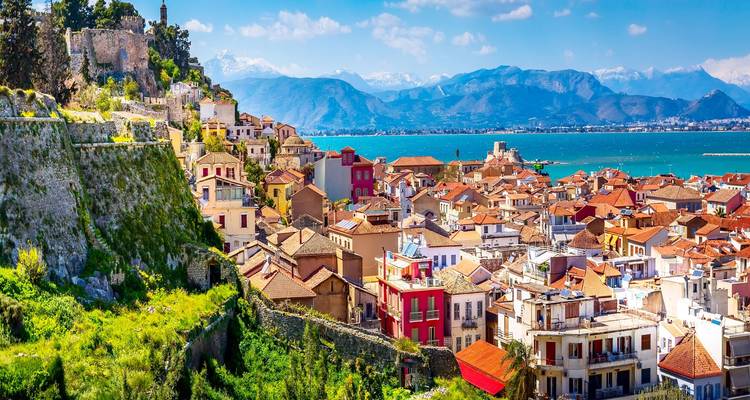 Vista panorámica sobre los tejados de terracota de Nafplio con bahía turquesa y montañas distantes