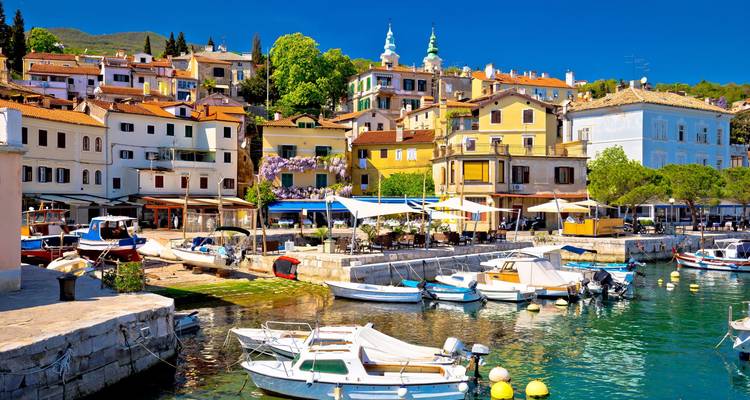 Bunte Uferpromenadenhäuser und kleine Boote im sonnigen Adriabadeort Opatija
