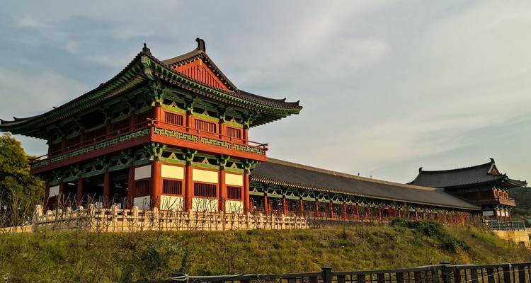 Edificio tradicional coreano con columnas rojas y techos de tejas.