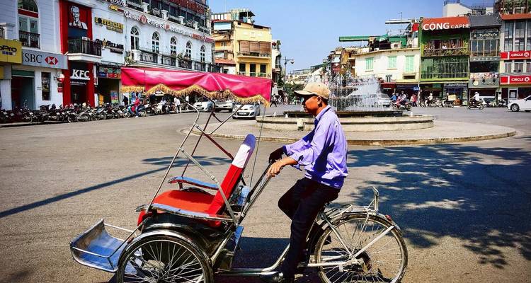 Street scene with a cyclist and Vietnamese architecture.