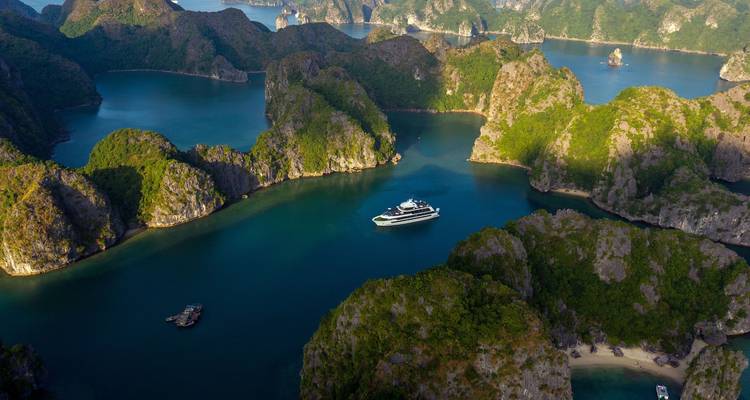 Aerial view of Halong Bay with islands and a cruise ship.