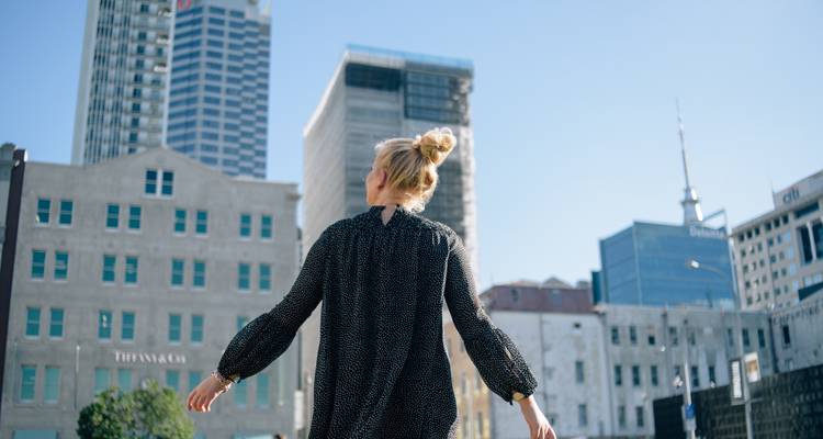 Personne marchant dans une ville avec des bâtiments modernes.