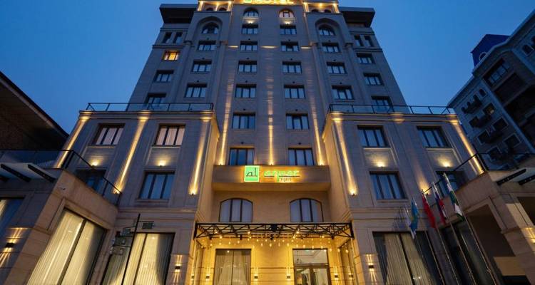 Eine elegante Hotelfassade mit Außenbeleuchtung während der Dämmerung.