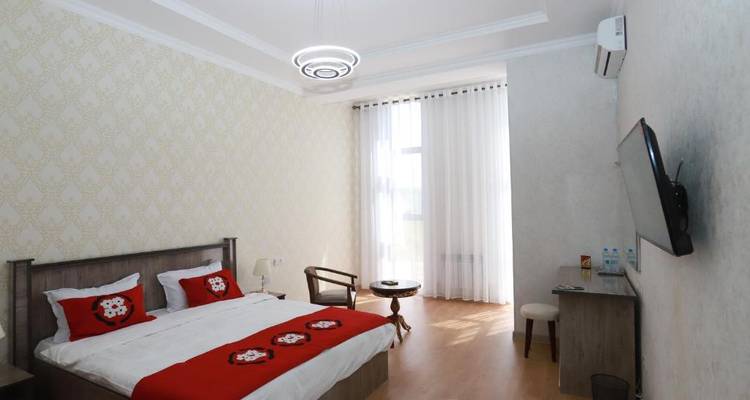 Ein Hotelzimmer mit einem weiß-roten Farbschema und einem Doppelbett.