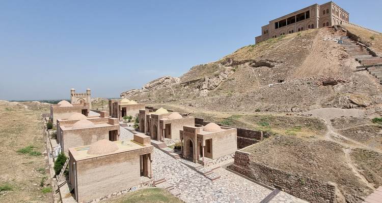 Sitio histórico con edificios antiguos y una fortaleza en la cima de la colina.