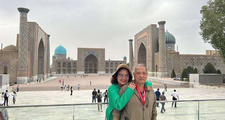 Un couple posant devant la place du Registan à Samarcande