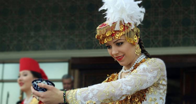 Une femme portant une robe ouzbèke traditionnelle tenant un bol
