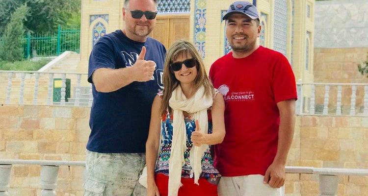 Un groupe de touristes posant devant une architecture traditionnelle