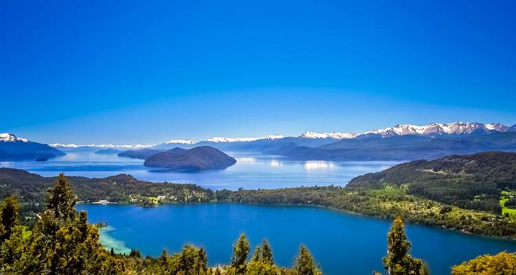 Vue magnifique sur le lac avec des montagnes lointaines sous un ciel dégagé.