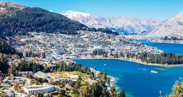 Vue aérienne d'une ville entourée de montagnes et de lacs.