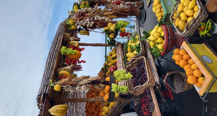 Puesto de frutas con una variedad de frutas vibrantes con vista al mar.