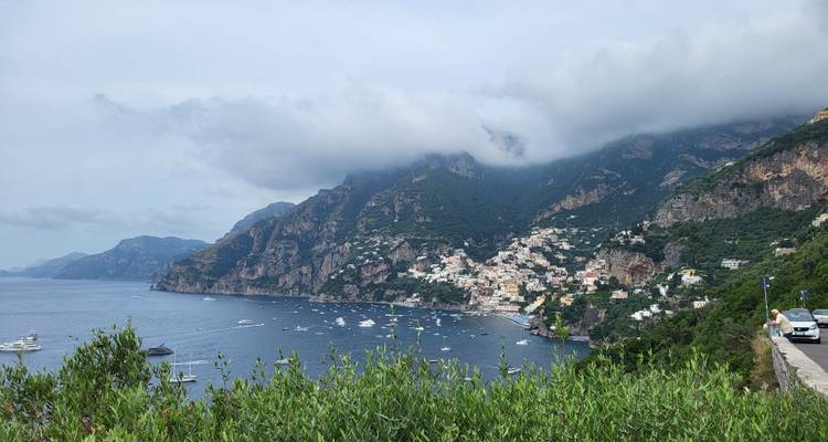 Pueblo costero con acantilados escarpados y barcos en el agua.