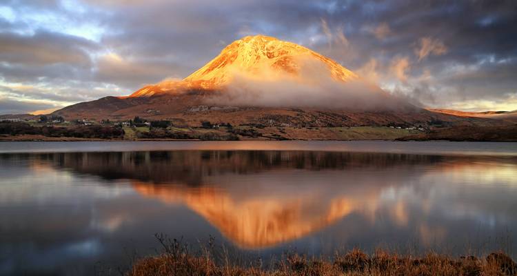 Mountain reflecting in a tranquil lake at sunset.