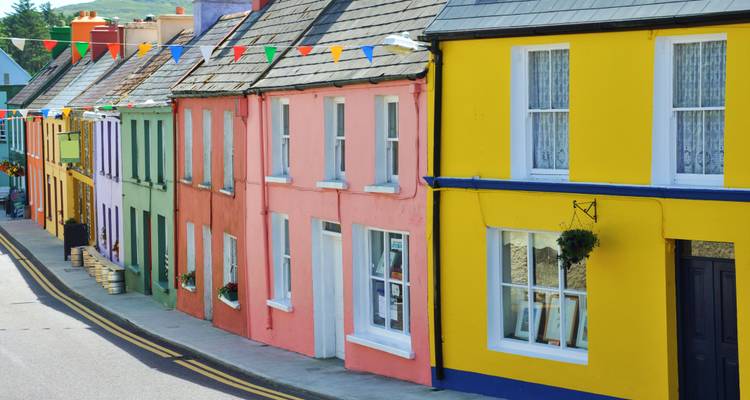 Colorful row of houses on a street with hanging decorations.