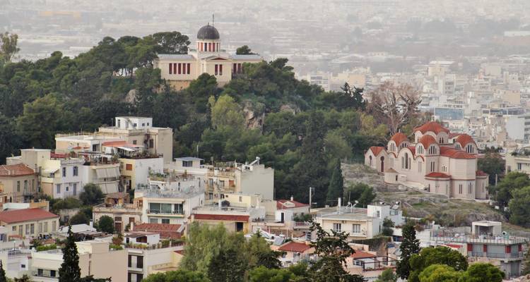 Un paisaje urbano con edificios históricos y un mirador en la cima de la colina.