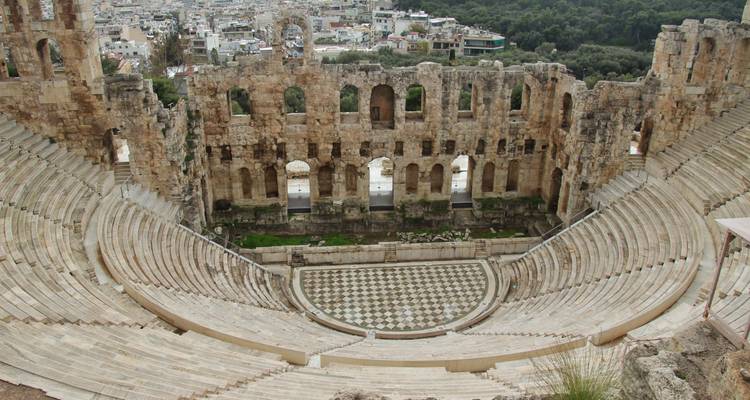 Anfiteatro antiguo con vista de la ciudad al fondo.