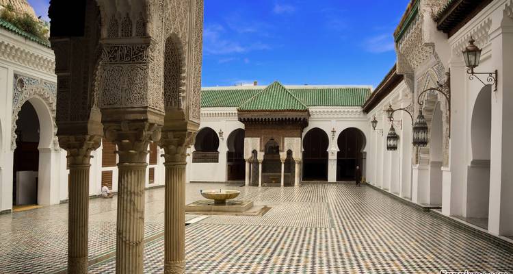 Historical courtyard with intricate architecture and a fountain.