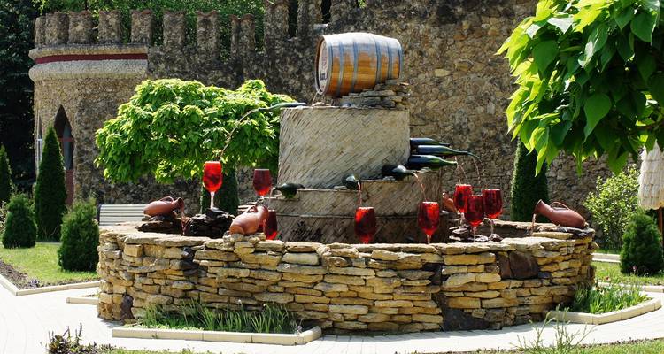 Fontaine à vin avec verres rouges et décoration.