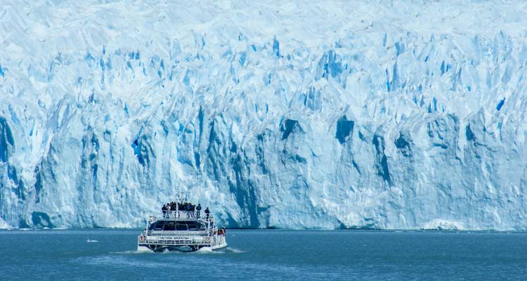 Un bateau s'approchant d'un mur de glacier massif.