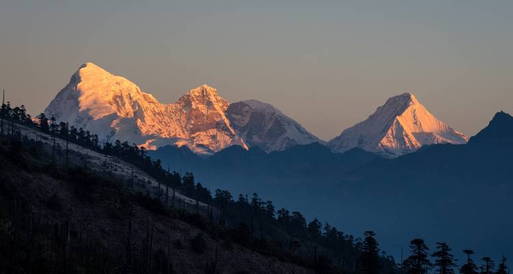 Majestätische schneebedeckte Berge, erleuchtet vom goldenen Stundenlicht