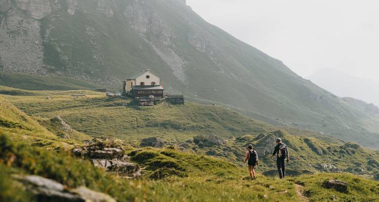 Deux randonneurs s'approchant d'un refuge de montagne.
