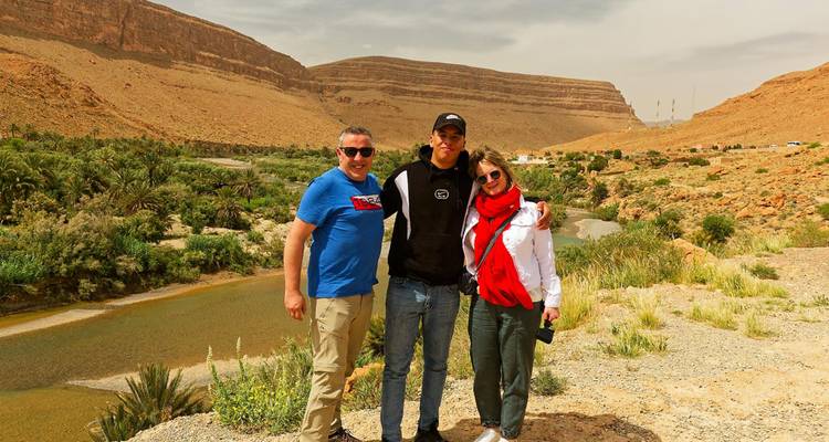 Drei Personen posieren vor einer Wüstenlandschaft.