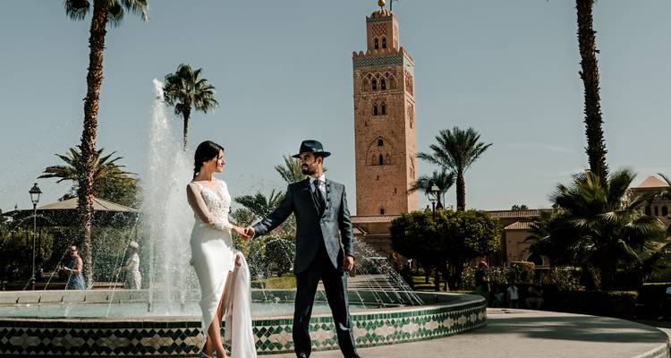 Ein Paar posiert tagsüber vor der Koutoubia-Moschee.