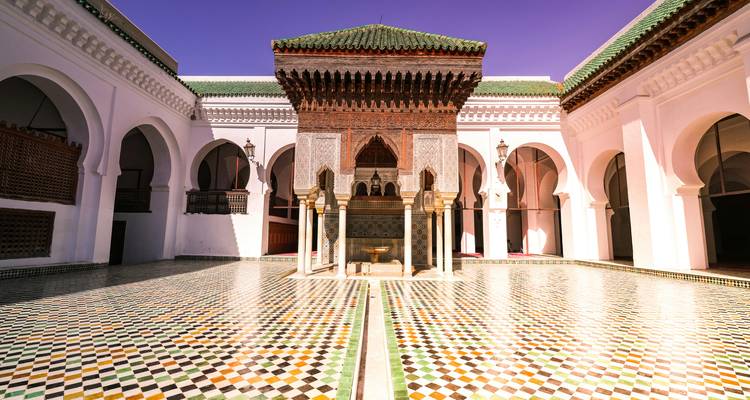 Patio de una mezquita con un suelo de mosaico colorido.