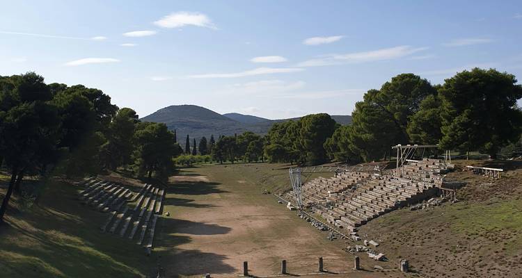 Ruinen eines antiken griechischen Stadions umgeben von Bergen.