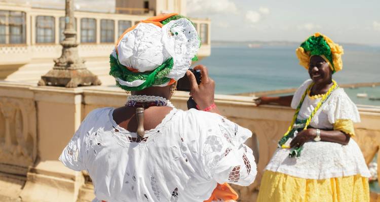 Deux femmes en tenue traditionnelle avec un paysage urbain en arrière-plan.