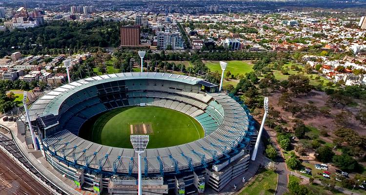 Vue aérienne d'un grand stade entouré d'un paysage urbain.