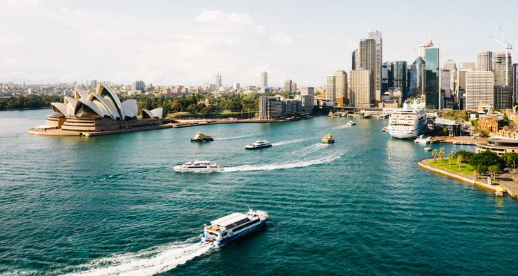 Vue aérienne du port de Sydney avec l'opéra et plusieurs bateaux.