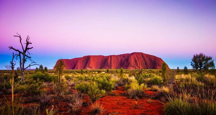 Formation rocheuse d'Uluru sous un ciel aux couleurs vives.