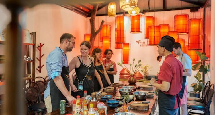 Clase de cocina con un chef instruyendo a los participantes.