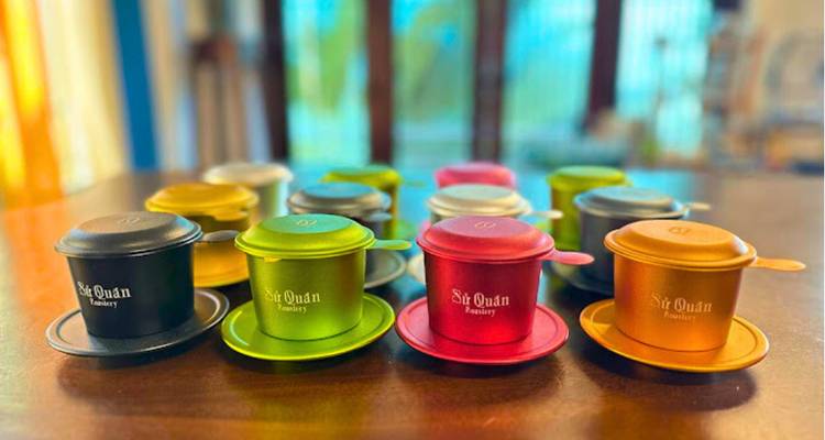 Cafeteras coloridas exhibidas sobre una mesa.