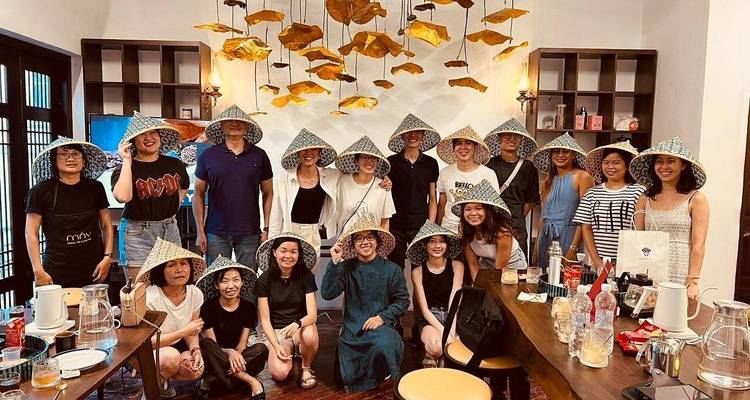 Grupo grande usando sombreros cónicos tradicionales posando dentro del taller de café
