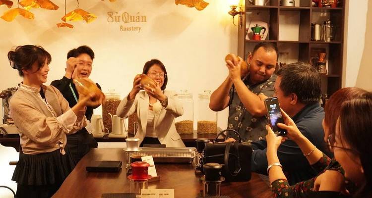 Los participantes agitando entusiastamente los shakers de café mientras otros graban en los teléfonos inteligentes