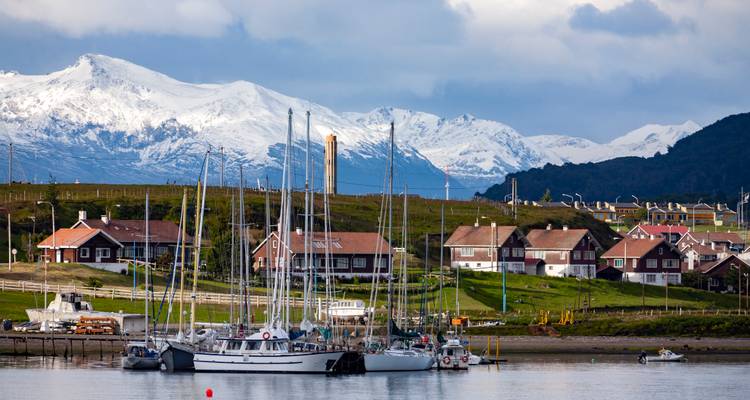Marina avec bateaux et montagnes enneigées.