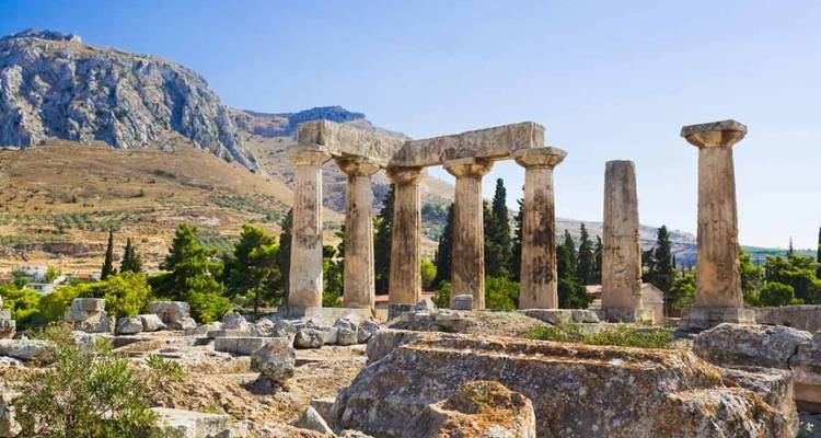 Ruinas de templo antiguo con columnas contra un telón de fondo montañoso.