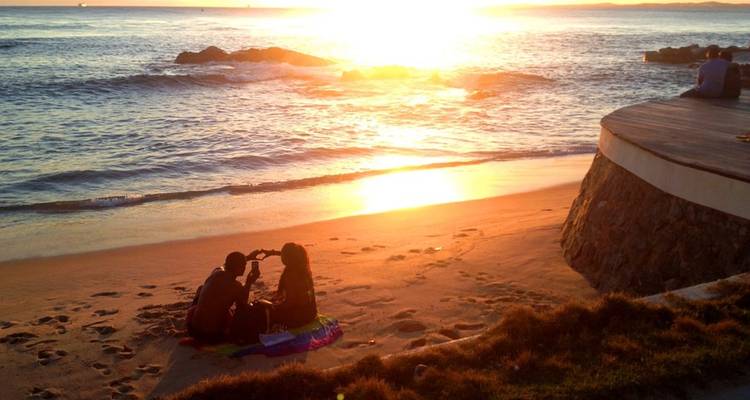 Pareja disfrutando de un atardecer en una playa.