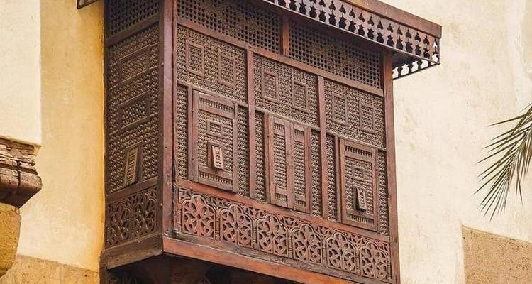 Balcón tradicional de madera con intrincado trabajo de celosía.