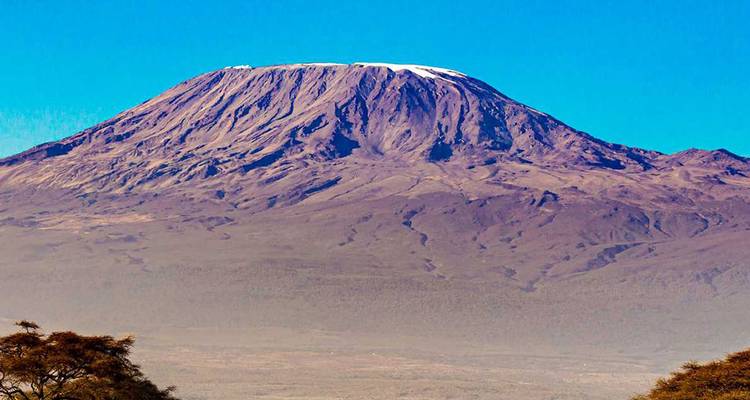 Clear view of a tall mountain under a bright blue sky.
